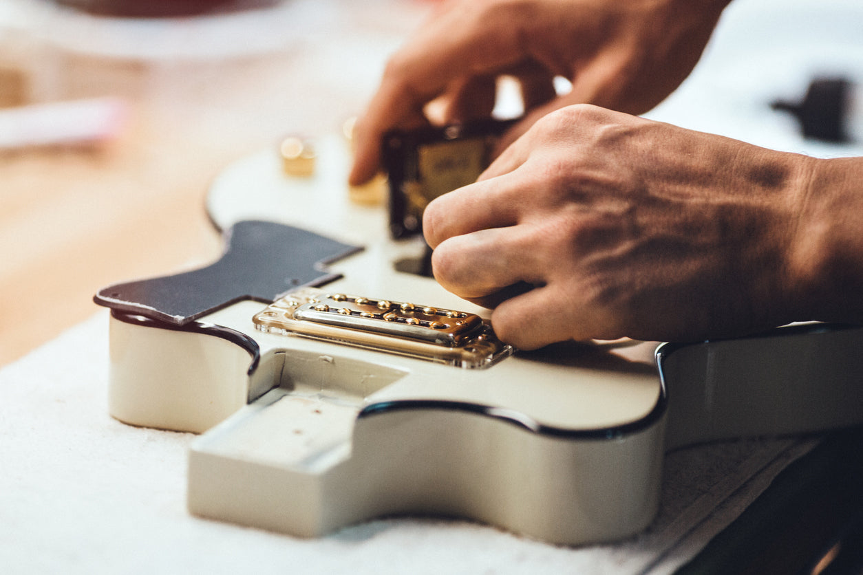 man working on the wiring of les paul humbucker pickups